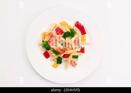 Top view of a delicious looking plate with freshly cooked pasta and vegetables on a light background. Healthy food and pasta concept. Stock Photo