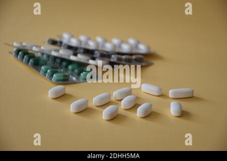 Various capsules and pills on beige background Stock Photo