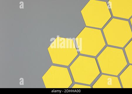 geometric composition with yellow paper hexagons on neutral gray background Stock Photo