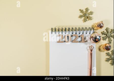 New years goals and new years resolution concept. Blank notepad or notebook and a pen isolated on a yellow background with christmas decorations Stock Photo