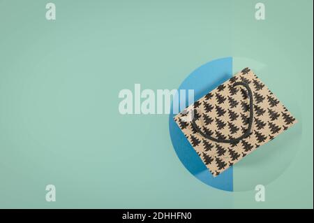 Christmas gift bag isolated on a blue background, flat lay top view with copy space for your design. Christmas shopping concept. Stock Photo