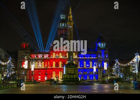 Glasgow, Scotland, UK. 11th Dec, 2020. Pictured: Glasgow City Chambers lit up in a Christmas Light and laser show in Glasgow George Square. Glasgow City Centre streets look a little business than yesterday, however still very empty considering Glasgow has finished phase 4 and entered phase 3 lockdown today of the coronavirus (COVID19) pandemic. Credit: Colin Fisher/Alamy Live News