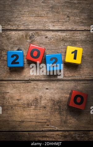 Change from 2020 to 2021 illustrated with toy number blocks on rustic wooden background Stock Photo