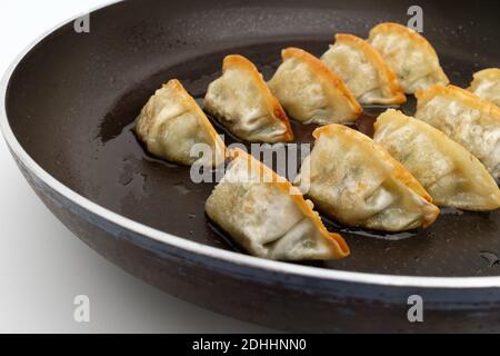 Frozen dumplings fried in oil on a frying pan Stock Photo