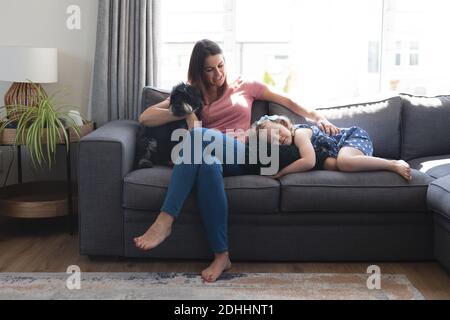 Caucasian mother and daughter having fun lying on couch Stock Photo