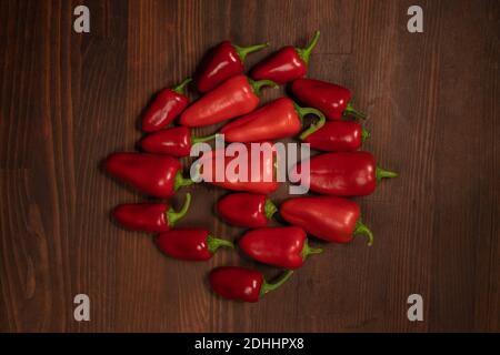 Top view. Stack of red pepper laid out on the wooden table. Large amount of red chilli peppers or capsicum Stock Photo