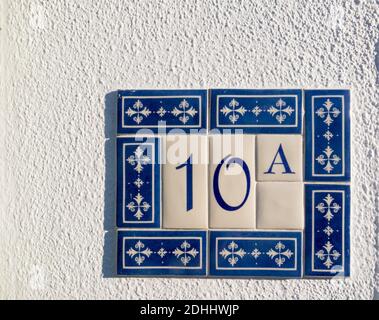 decorative ceramic tiles surrounding a number on a house wall Stock Photo