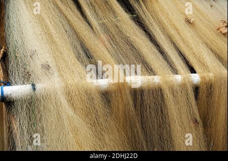 Close-up at texture of thin rustic fishing nets drying outdoor. Stock Photo