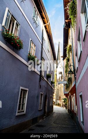 Narrow Alley With Historic Buildings And View to Church In Picturesque Lakeside Town Hallstatt In Austria Stock Photo