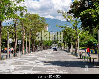 MEDELLIN, COLOMBIA - Dec 03, 2020: Medellin, Antioquia, Colombia - December 2 2020: Street with Little Traffic, with Trees on the Edges and People Wal Stock Photo