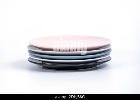 Stack of five colorful empty plates isolated on white background, side ...