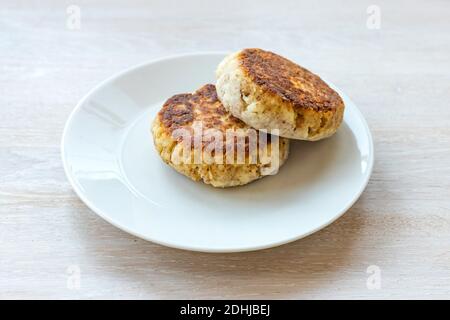 Homemade cottage cheese pancakes syrniki stack on plate on white table background Stock Photo