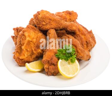 A fried chicken with lemon and parsley on a white plate Stock Photo