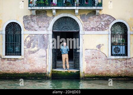 An elderly man alone on a canal during Covid19 in Venice Italy Stock Photo