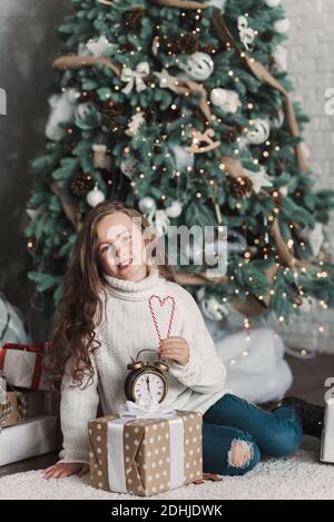 Happy excited girl child holding christmas candy canes. Happy little girl excited at Christmas Eve. Hope concept Waiting for Santa claus. Hopeful chil Stock Photo