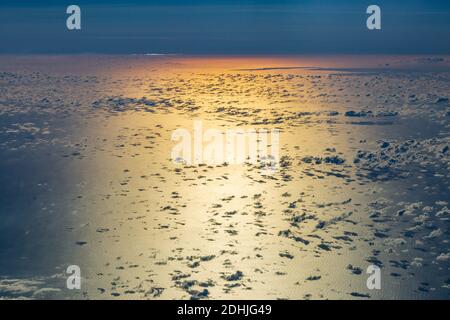 Sunset over the ocean, viewed from the flight deck of an airplane Stock Photo