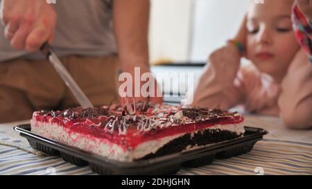 Father cuts the cake with the children. Stock Photo