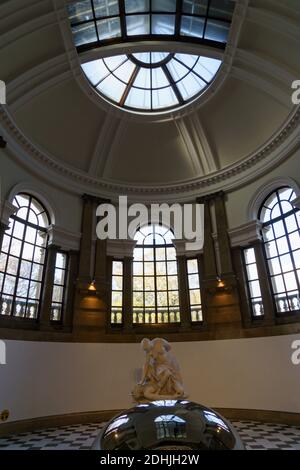 Within Cartwright Hall, an art museum with a dome-shaped ceiling and windows and a white carved figure in the center, there is Bradford, West Yorkshire, UK. Stock Photo