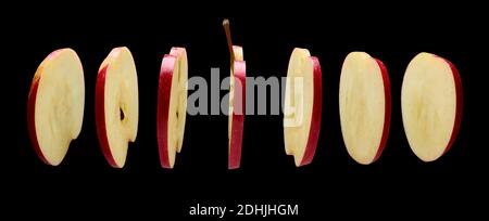 Red Apple slices levitating in the air on black background Stock Photo