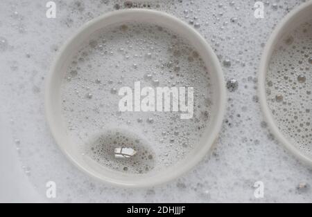 washing up soap suds and mugs in kitchen sink Stock Photo