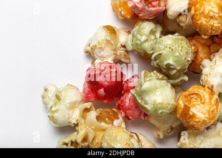 From above closeup of sweet colorful popcorn scattered on white background in studio Stock Photo