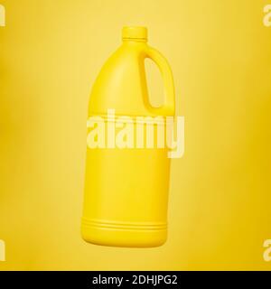 Bright plastic container from liquid detergent placed on vivid yellow background in studio Stock Photo
