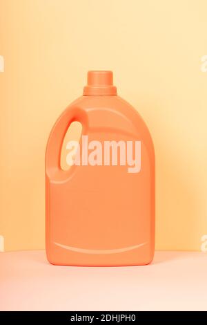 Bright plastic container from liquid detergent placed on vivid yellow background in studio Stock Photo