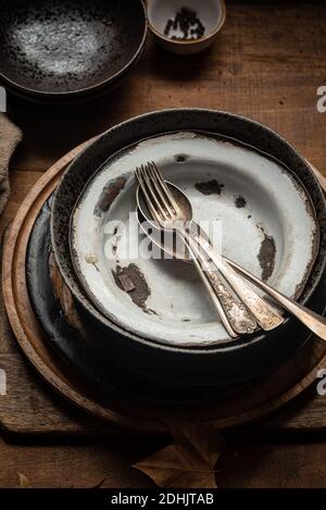 From above of pile of old rusty metal plates stacked on wooden table in kitchen Stock Photo