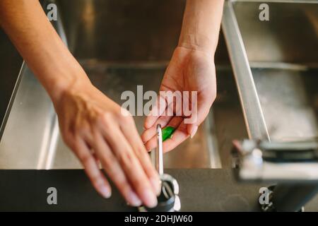 From above of crop female squeezing antibacterial liquid soap and preparing for washing hands Stock Photo