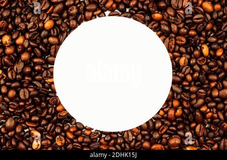 Coffee beans are scattered over the surface on a blank white background. a handful of brown coffee beans. Coffee background with copy space for an Stock Photo
