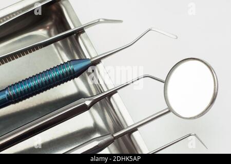 Different dental tools are lying in the medical tray. Isolated on white background. Stock Photo