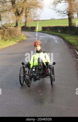 Mature man riding a recumbent bicycle along a country road Stock Photo