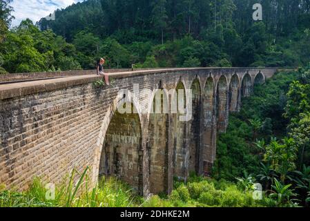 A young woman admiring the view from the Nine Arch Bridge in Ella, Sri Lanka Stock Photo