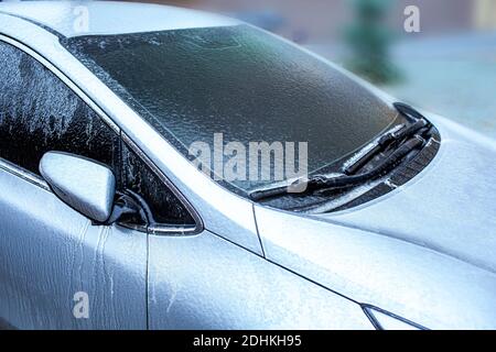 Freezing rain, anomalies of nature. Car windshield window and windscreen wipers in ice after freezing rain. Soft focus technique Stock Photo