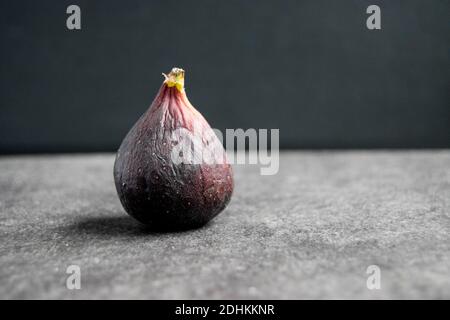 Single over ripe fig against a dark background Stock Photo