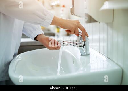 Workers hands being carefully washed in a sterile bathroom before working within food production factory. Stock Photo