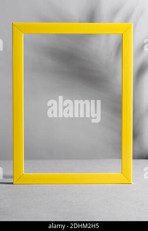 Yellow frame with palm shadows on grey background. Trendy colors 2021. Stock Photo