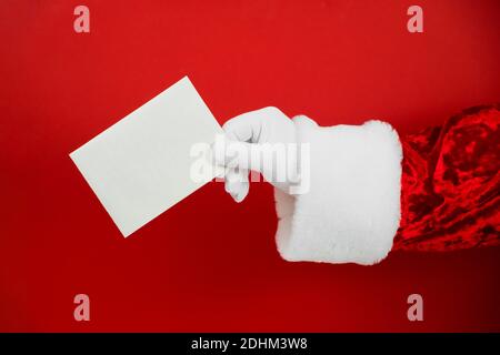 Santa Claus hand holding empty Christmas card. Mock up blank sign Stock Photo