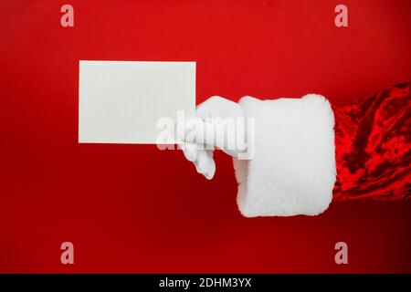 Santa Claus hand holding empty Christmas card. Mock up blank sign Stock Photo