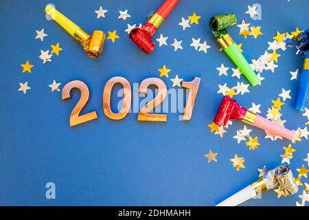 Gold pink balloons in form of numbers 2021 with colorful shiny confetti on blue background. Happy New Year celebration. Flat lay, top view Stock Photo