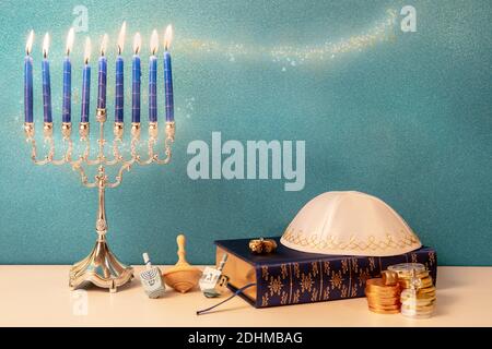 concept of of jewish holiday hanukkah with traditional chandelier menorah, wooden spinning top toy dreidel and other religious attributes Stock Photo