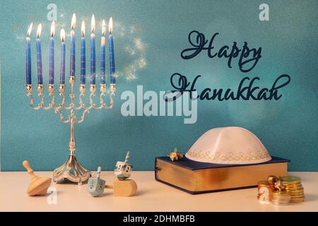 greetings with jewish religious holiday hanukkah with traditional chandelier menorah, spinning top toys (dreidel) and other attributes Stock Photo