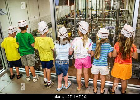 Alabama Sylacauga Blue Bell Creameries ice cream manufacturing plant production,children boys girls tour school field trip students wearing hats,looki Stock Photo
