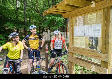 Birmingham Alabama,Oak Mountain State Park,mountain bike trail man woman female couple riding bicycles,looking reading information kiosk, Stock Photo