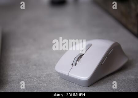 Grey white wireless computer mouse lying on a desk Stock Photo