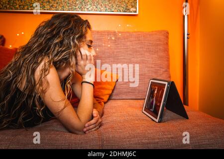 Young caucasic woman watching a series on the sofa Stock Photo