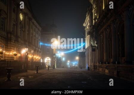 Christmas decorations are shrouded in mist on a winter night on Bristol's Corn Street. Stock Photo