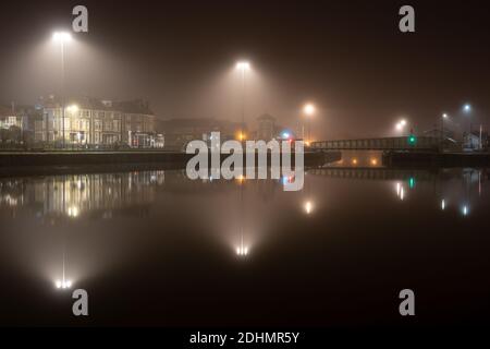 Streetlights are diffused by mist rising from Cumberland Basin on an autumn night on Bristol's Floating Harbour. Stock Photo