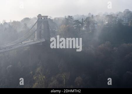 Autumn mist rises from trees beside the Clifton Suspension Bridge at Leigh Woods in the Avon Gorge between Bristol and Somerset. Stock Photo