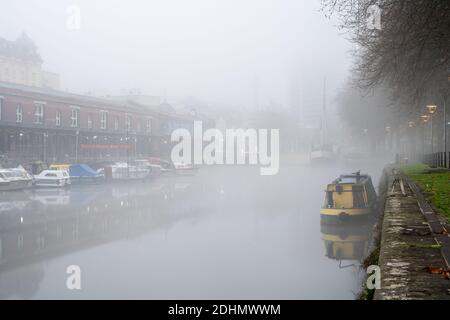 Boats and buildings of Bristol's Harbourside are shrouded in fog on an autumn morning. Stock Photo